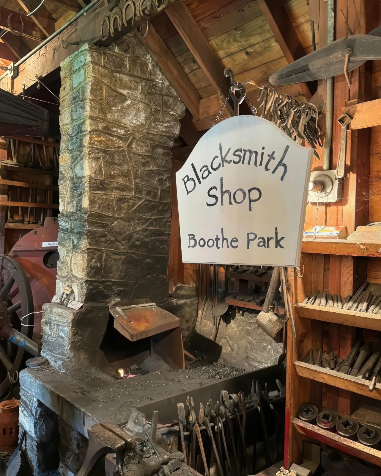 Forge, tools, and Blacksmith Shop sign inside the Boothe Park Blacksmith Shop