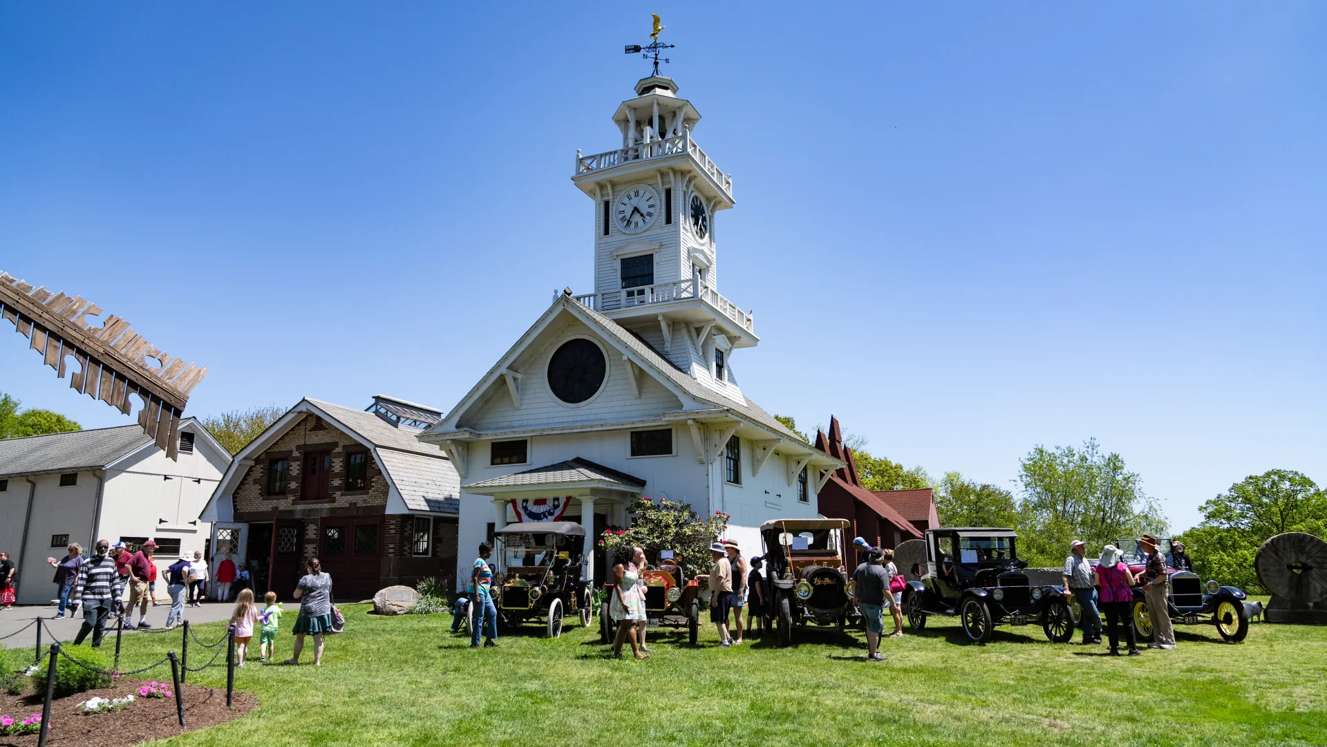 The Clocktower Museum during opening day with visitors and antique automobiles on the lawn