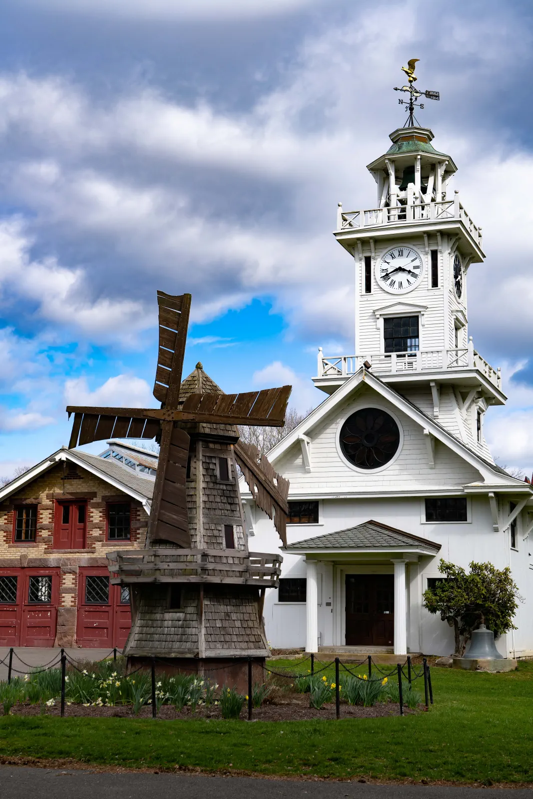 The Boothe Park miniature windmill and Clocktower Museum beneath spring clouds