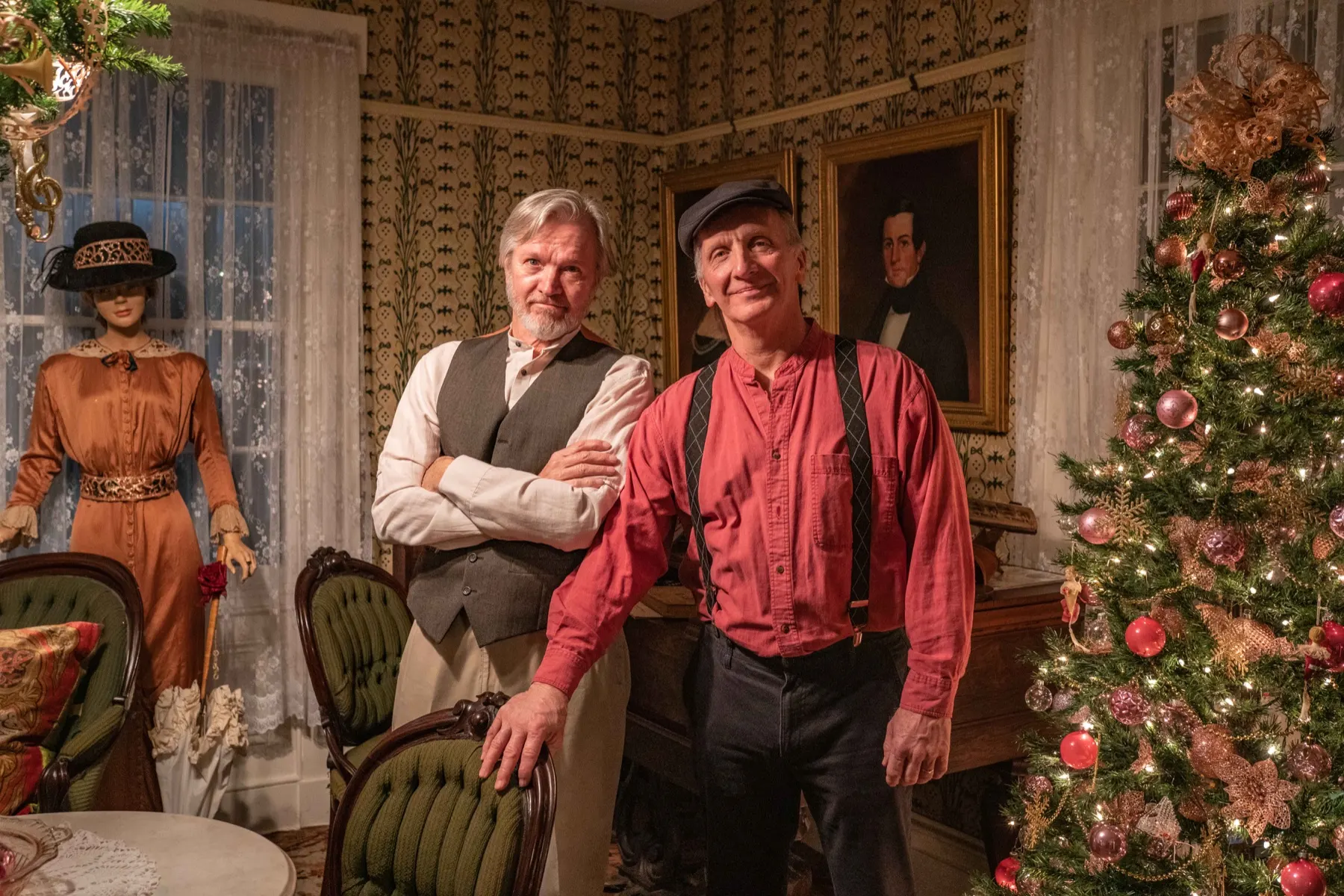 Volunteers in period clothing inside a decorated historic room at Boothe Park