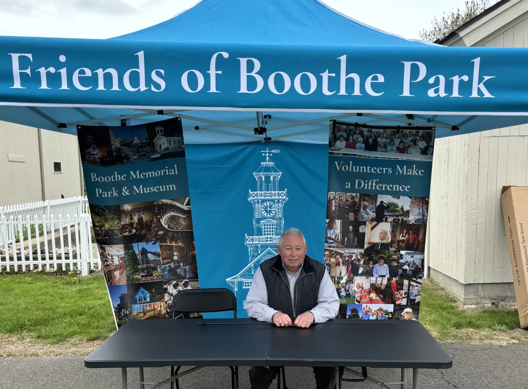 A Friends of Boothe Park volunteer welcoming visitors at an outreach table